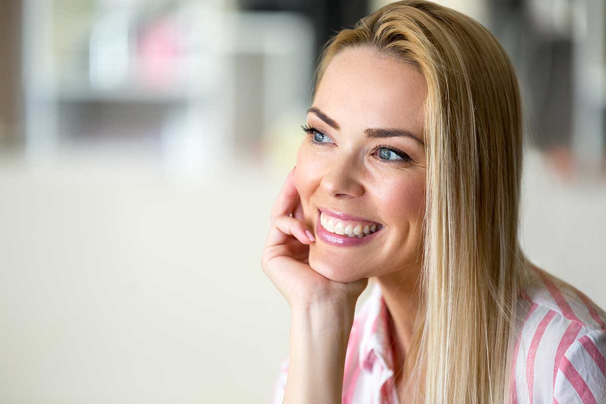 Smiling woman resting her face on her hand