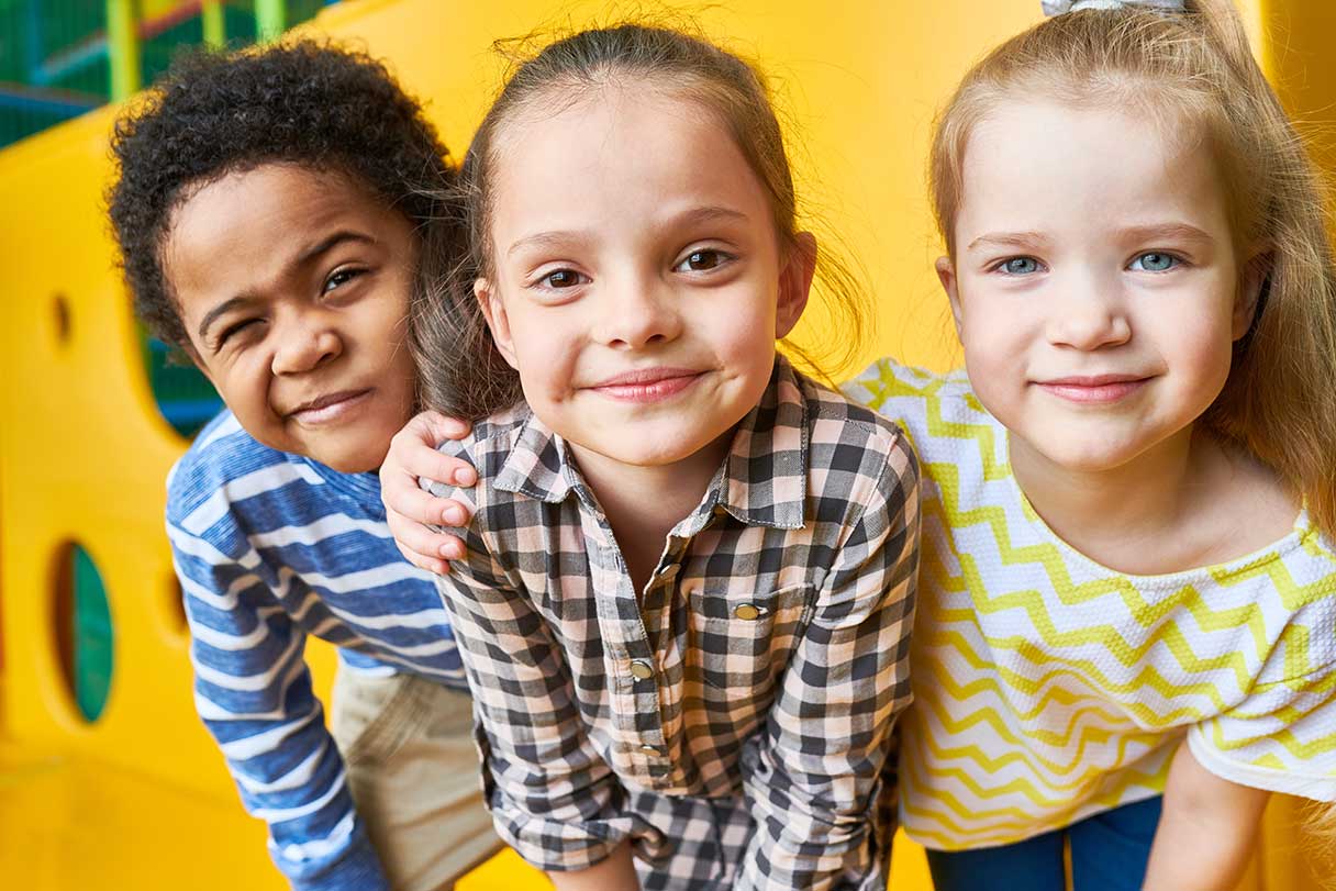 Group of three children, sitting on playground