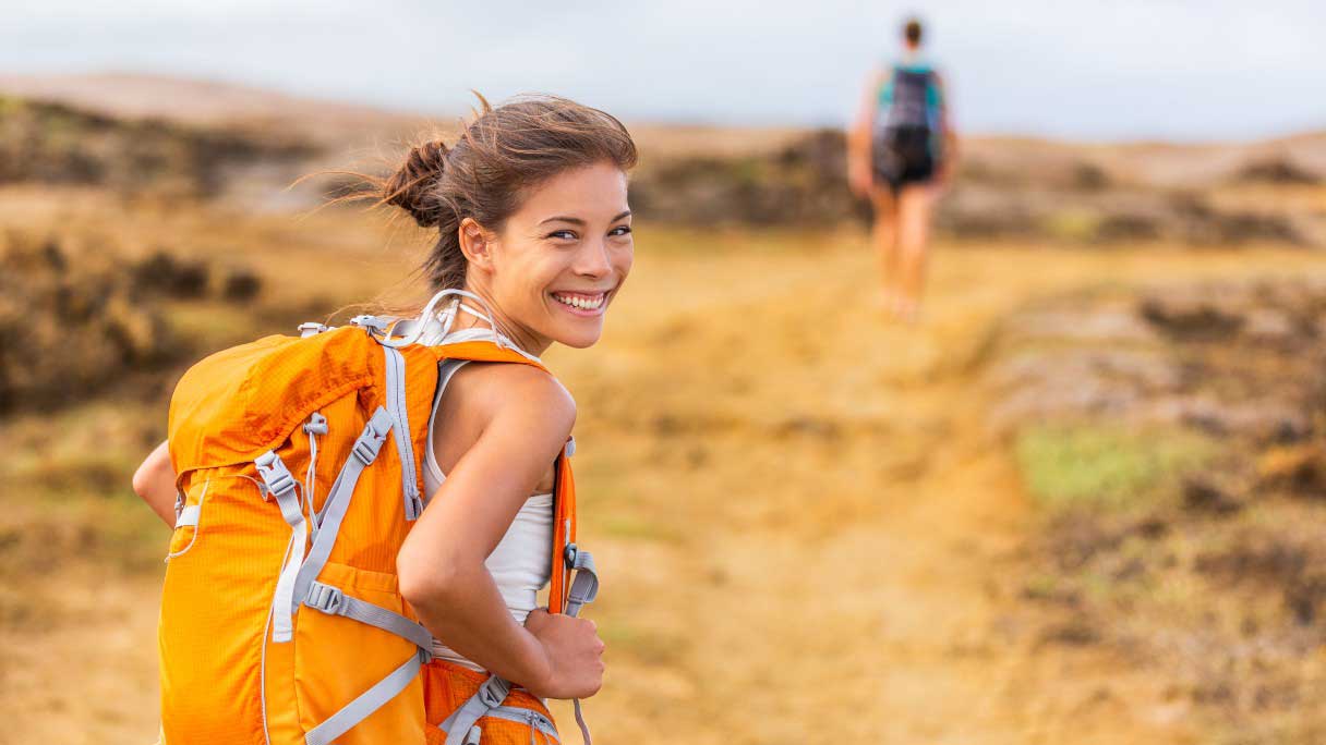 Woman on trail with back pack, clear skin