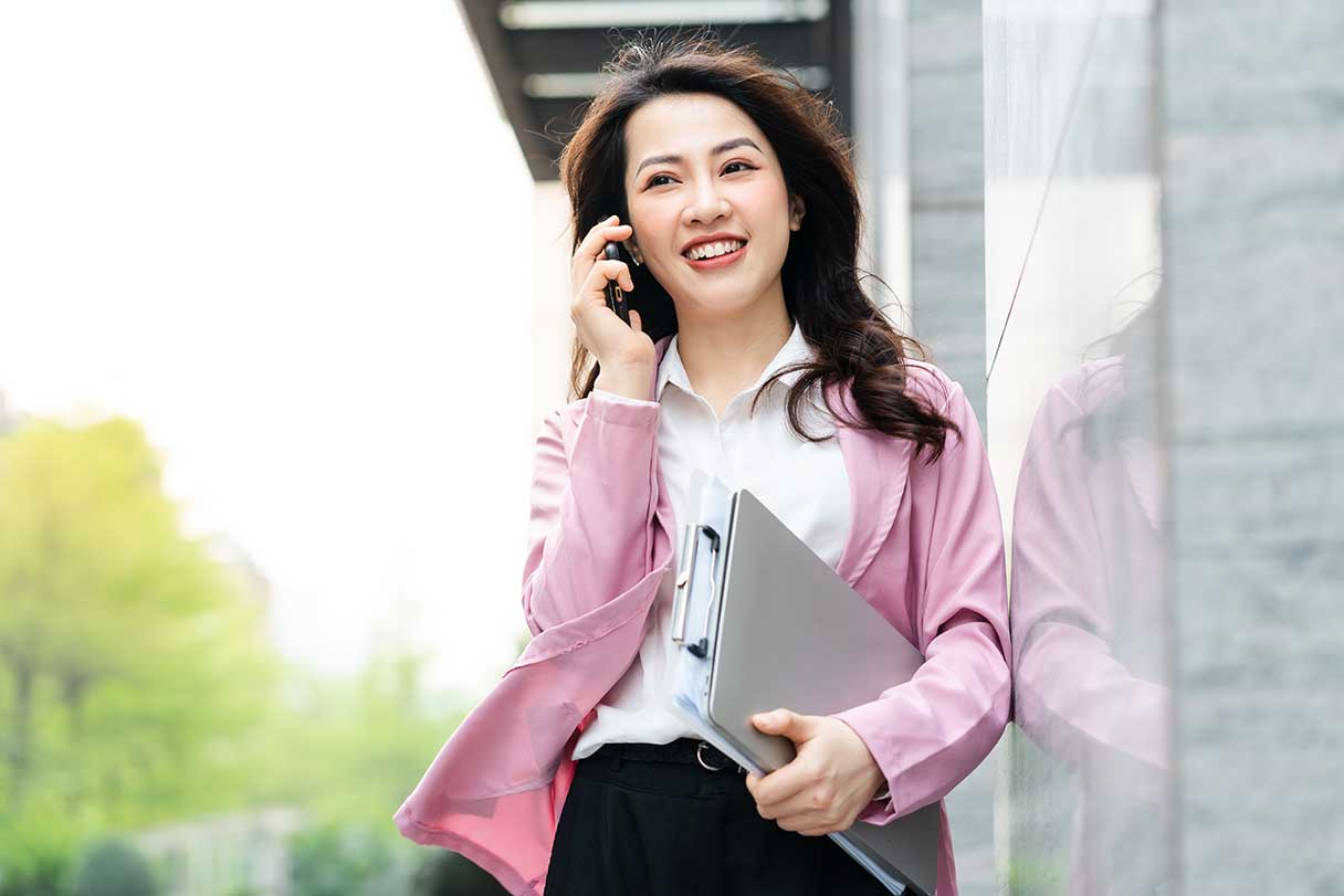 Smiling woman on cellphone, walking outside