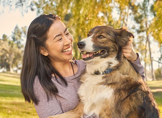 Smiling woman petting white and brown dog