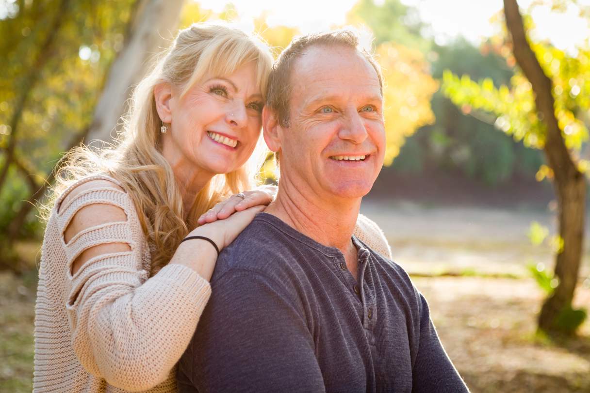 Senior couple outside, both smiling