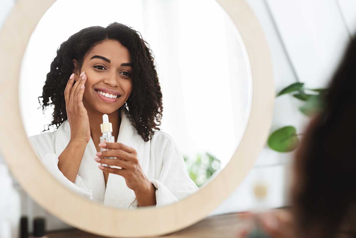 Woman applying facial serum to her face