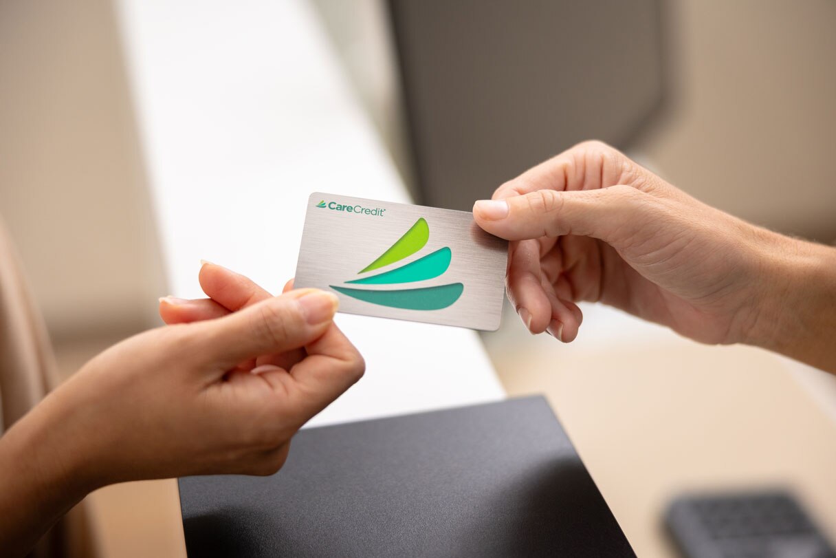 Hands exchanging CareCredit credit card