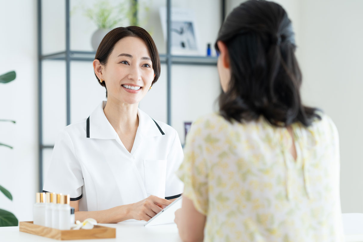 Cosmetic receptionist at front desk speaking with client