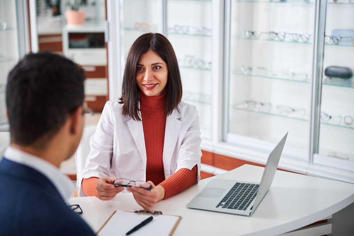 Provider next to laptop, speaking with patient