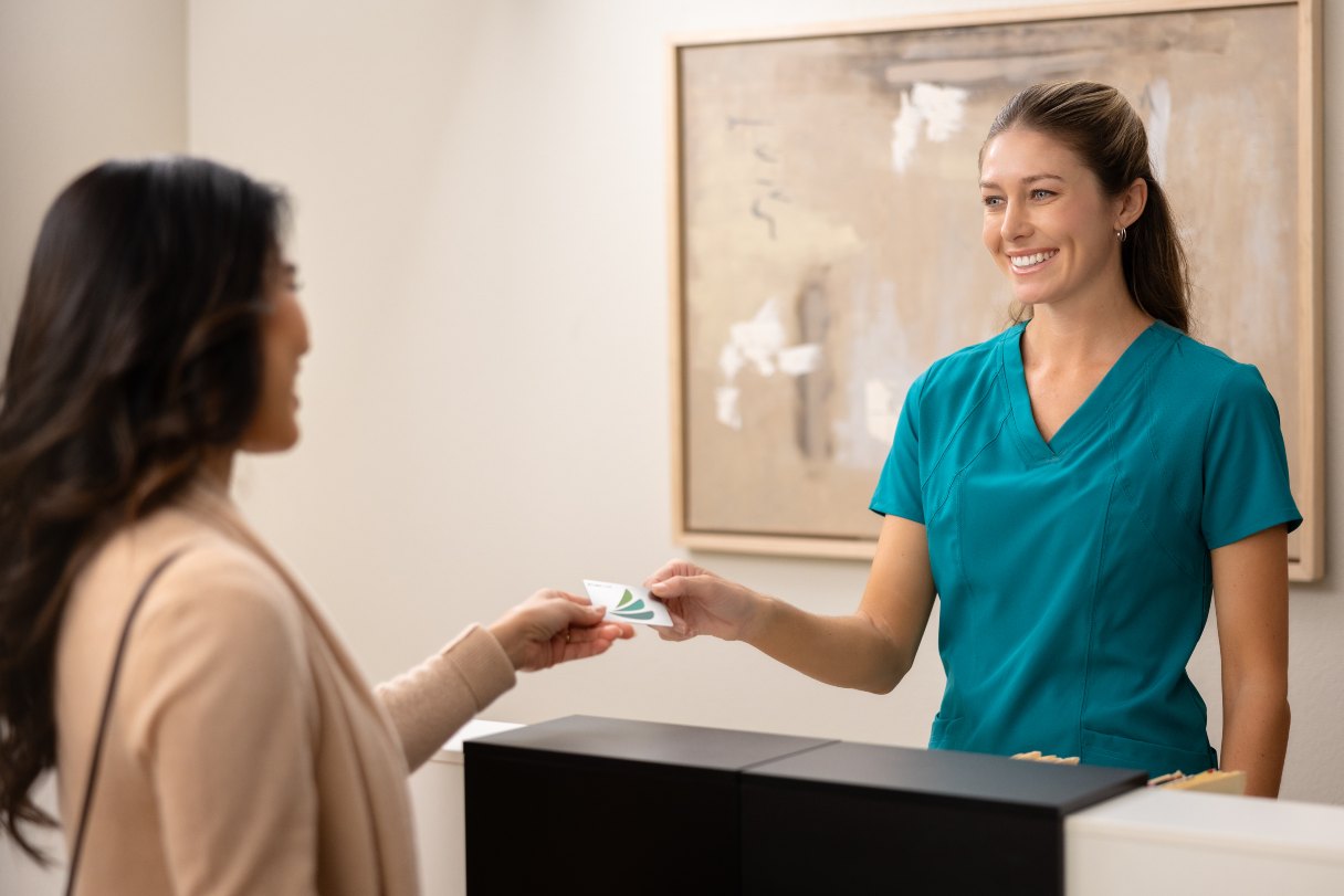 Woman paying healthcare receptionist with CareCredit credit card