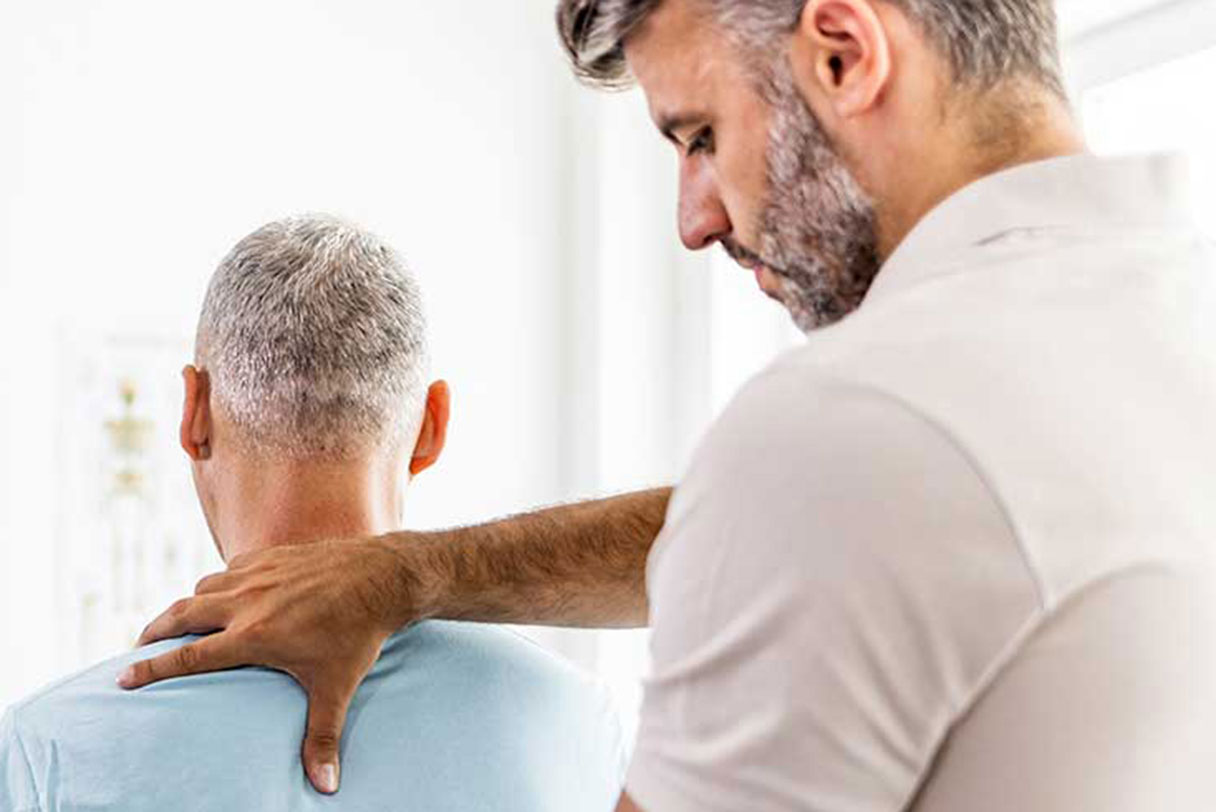Chiropractor stretching man's shoulder
