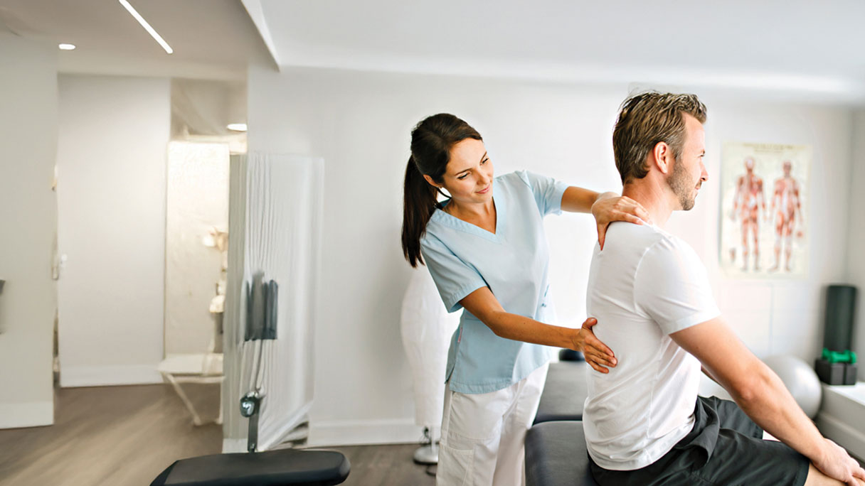 Chiropractor adjusting man's back