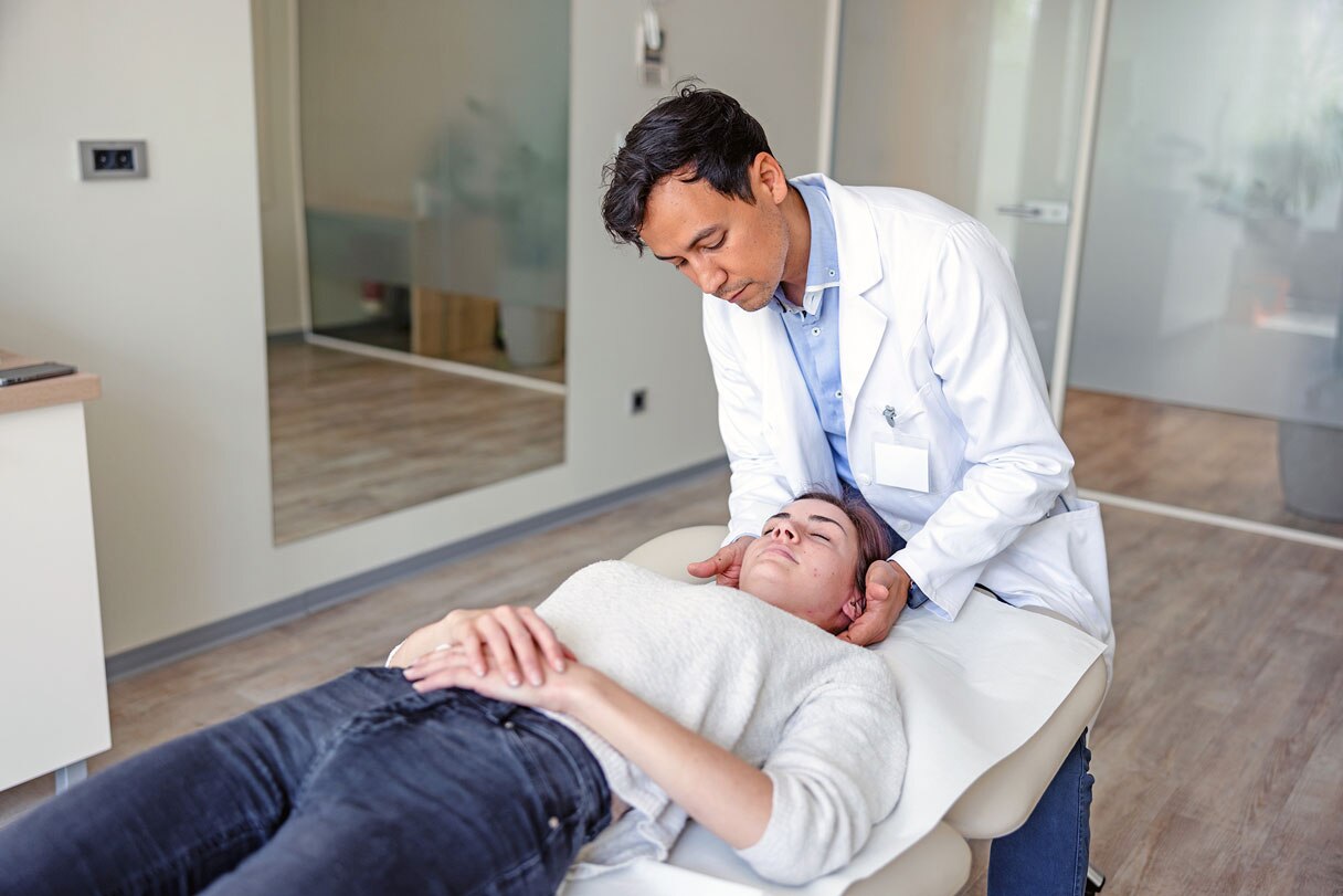 Chiropractor adjusting woman's neck on adjustment table