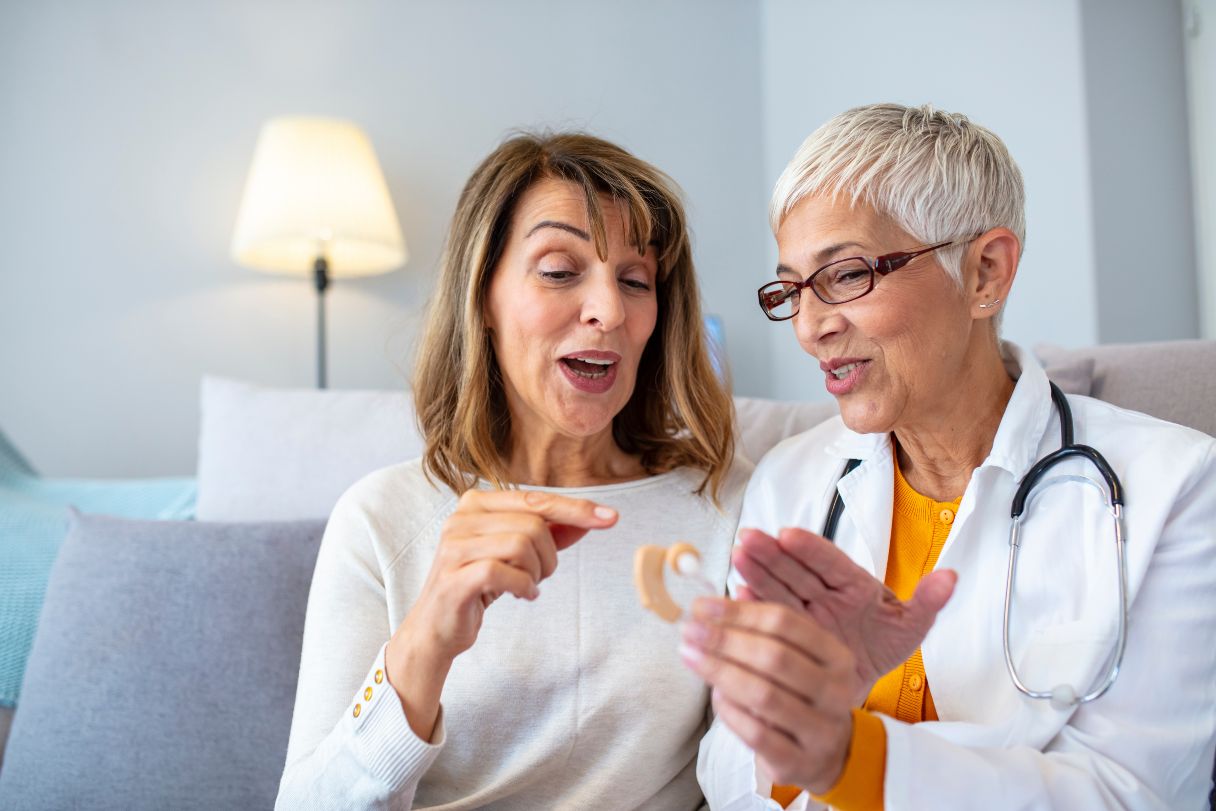 Doctor showing woman a hearing aid
