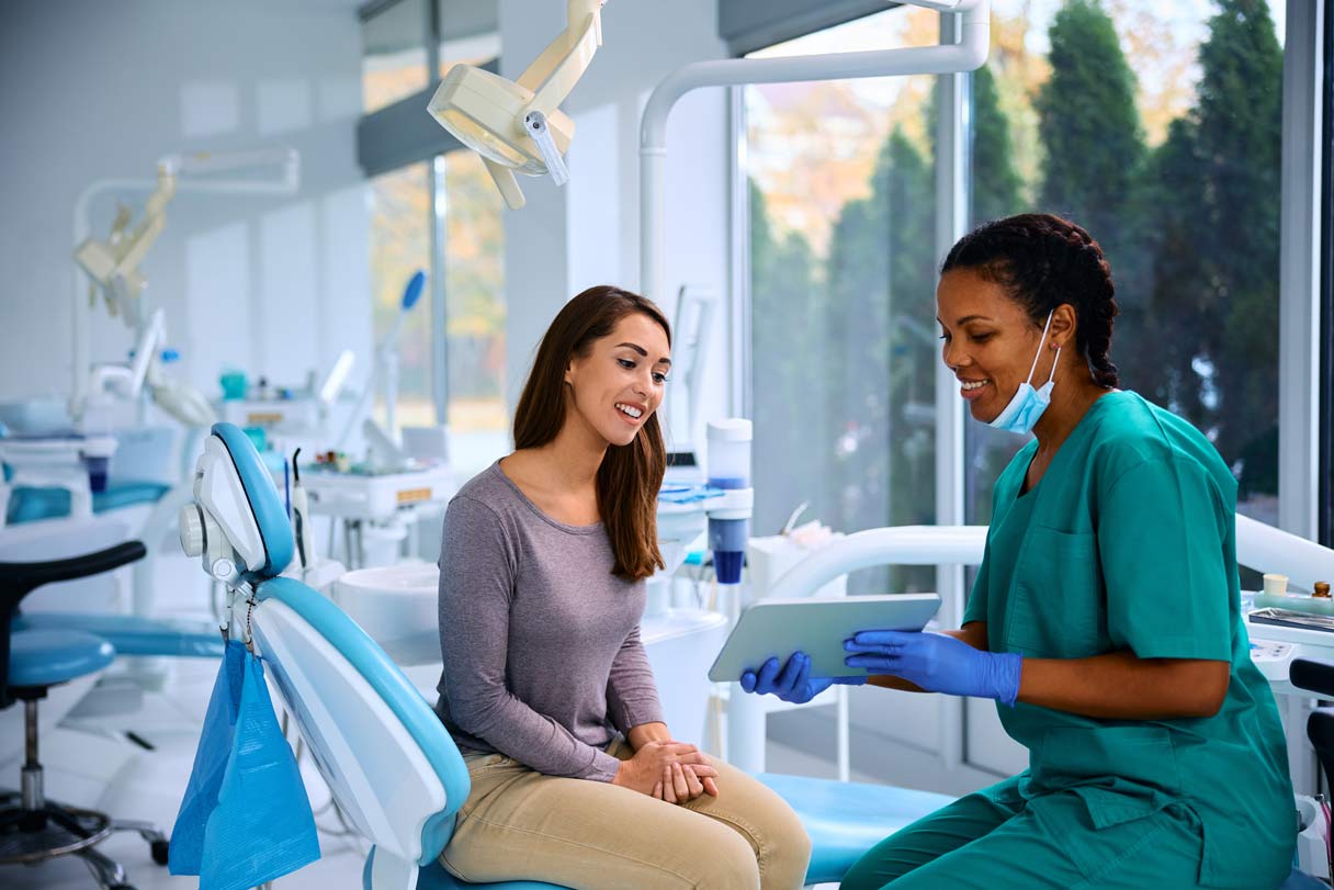 Dentist hygienist showing patient a tablet device