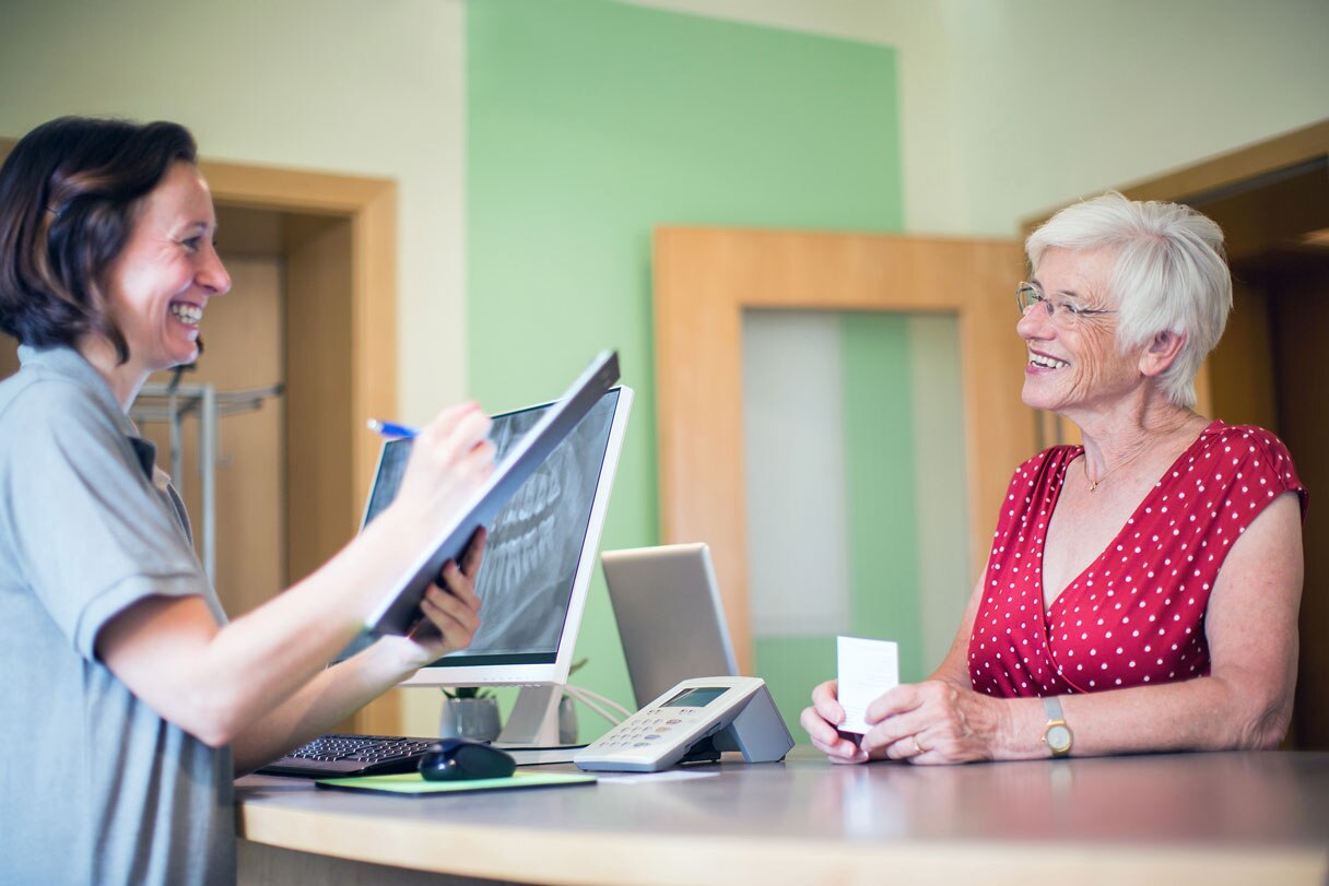 Dental receptionist speaking with patient