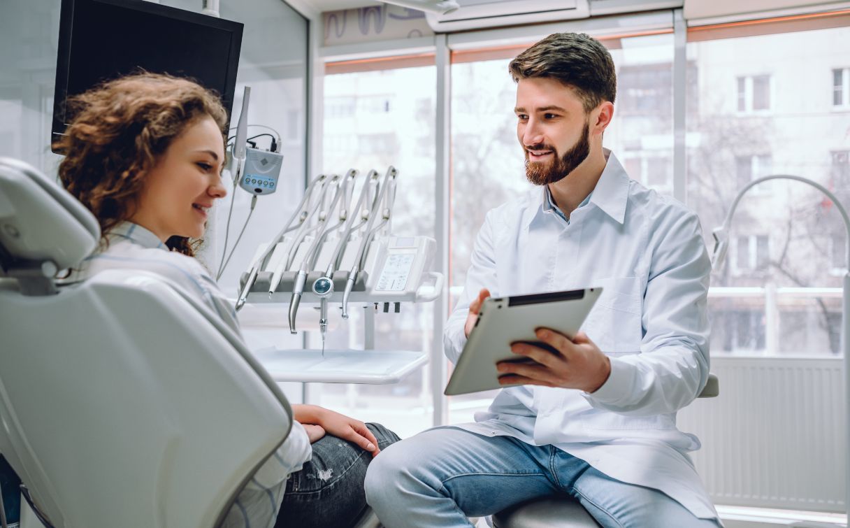 Dentist showing woman a tablet screen