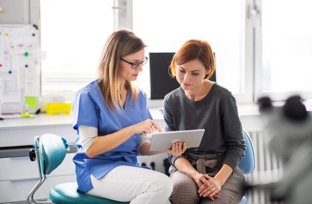 Dentist showing woman a tablet screen