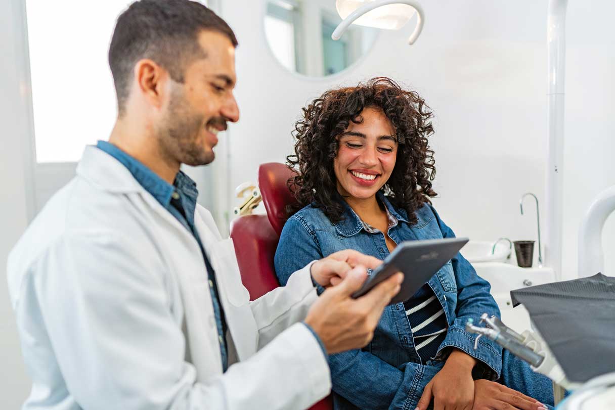 Dentist showing woman a tablet device