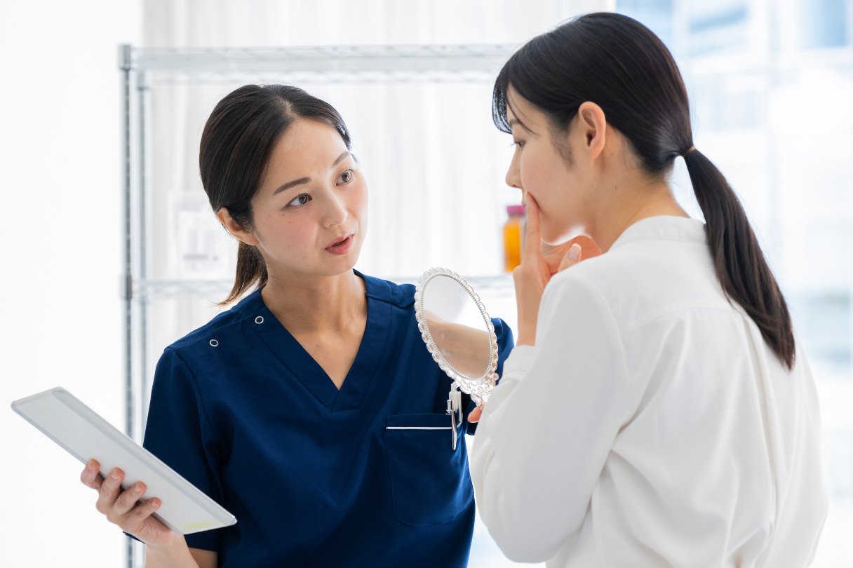 Provider speaking with woman, woman holding handmirror