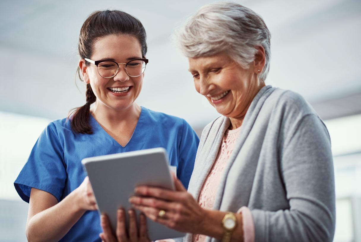 Provider showing a patient a tablet device, both smiling