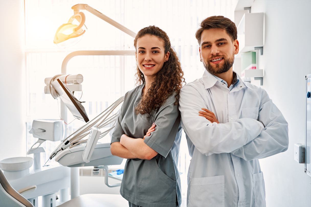 Two dental professionals standing back-to-back
