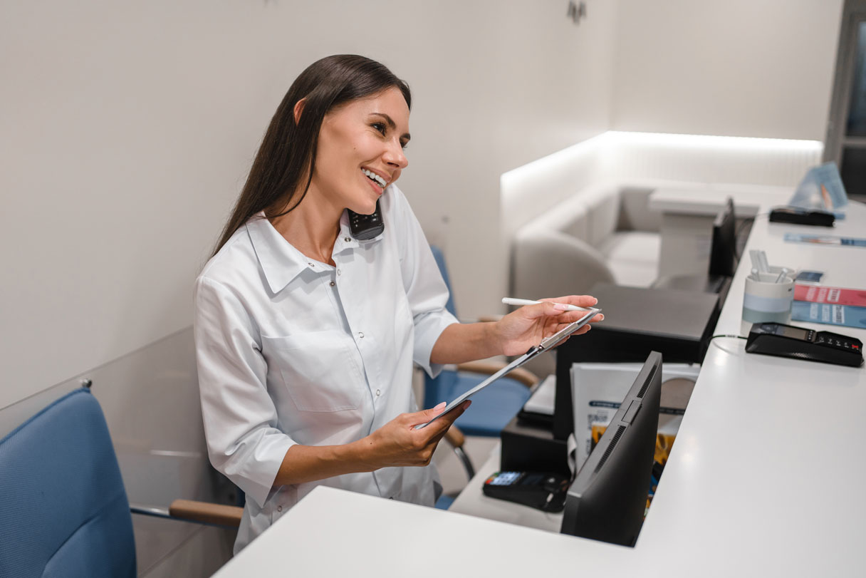 Receptionist on phone, holding documents
