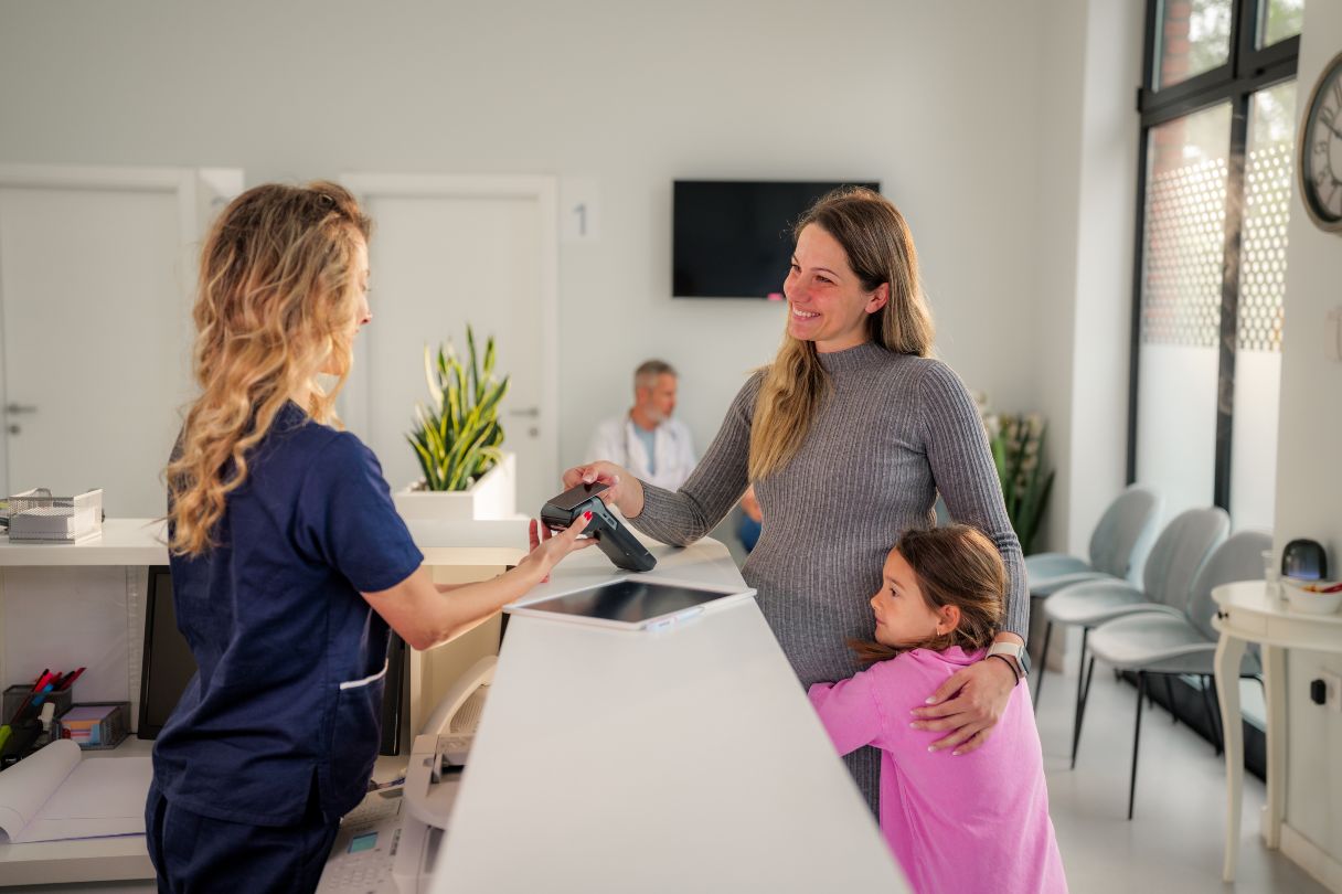 Woman paying healthcare receptionist with credit card