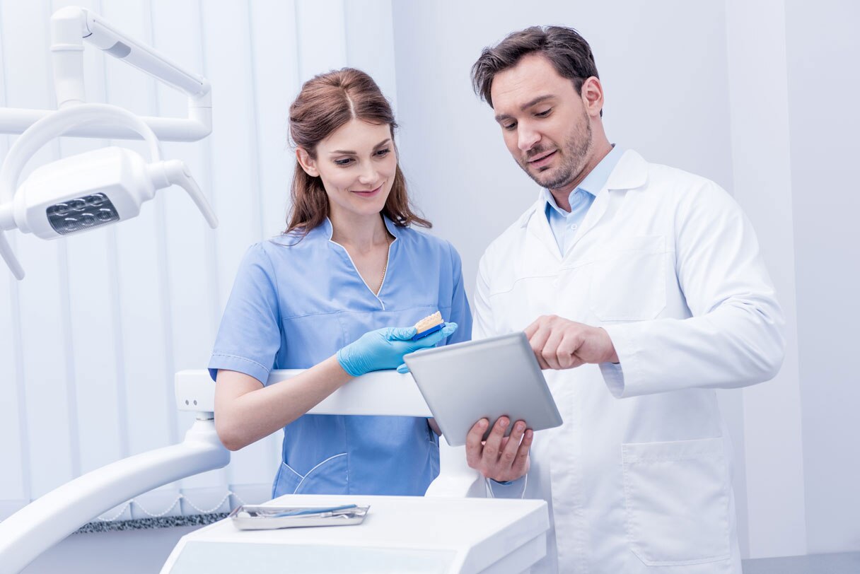 Dentist showing hygienist a tablet device