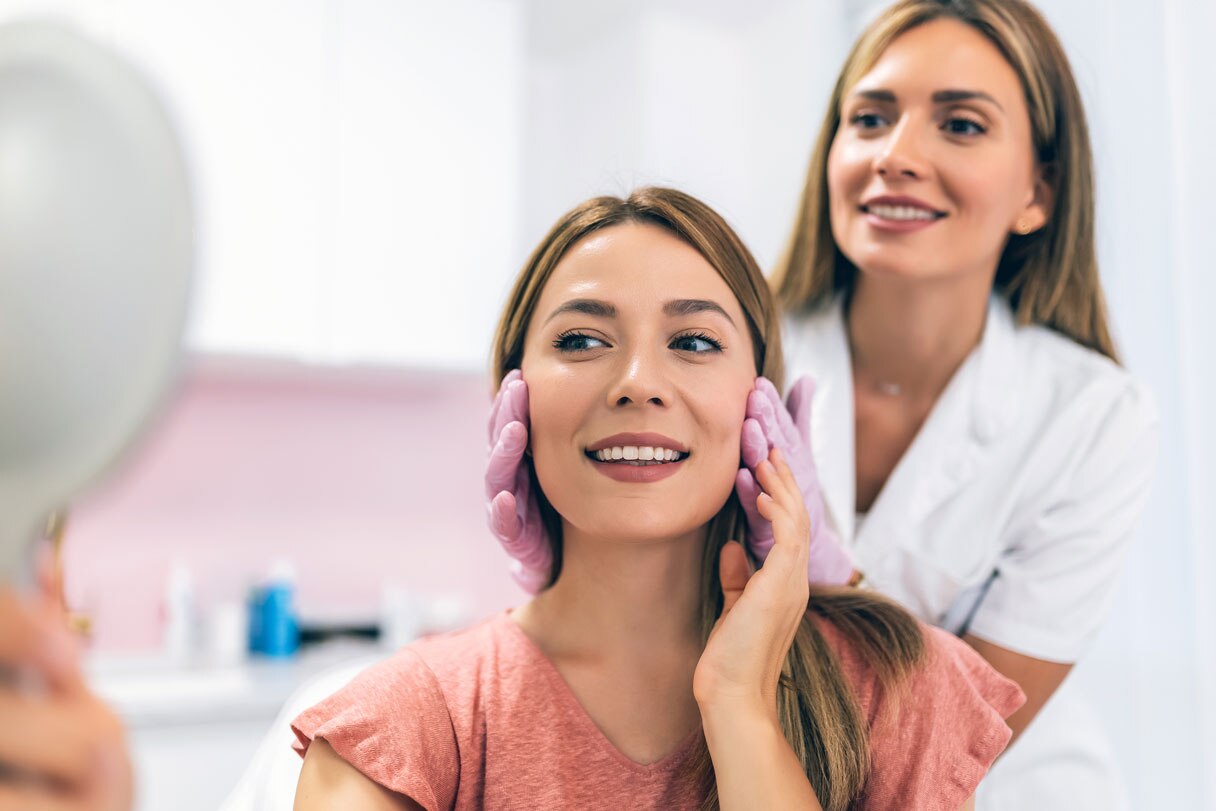 Cosmetic professional showing client face in mirror