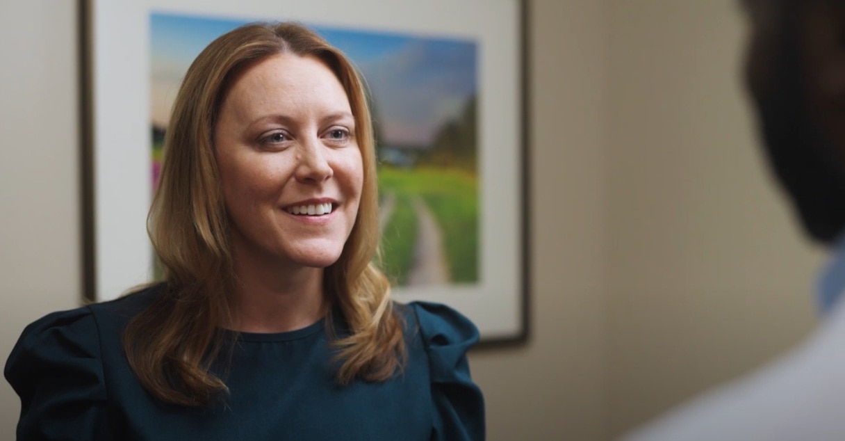 Close-up of a woman smiling, speaking with healthcare professional