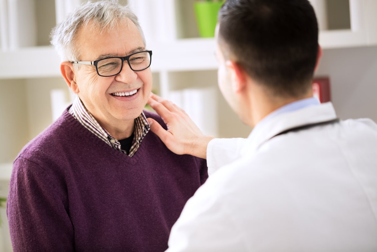 Healthcare professional speaking with a man in glasses