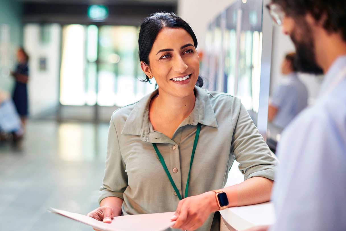 Woman holding papers speaking with patient