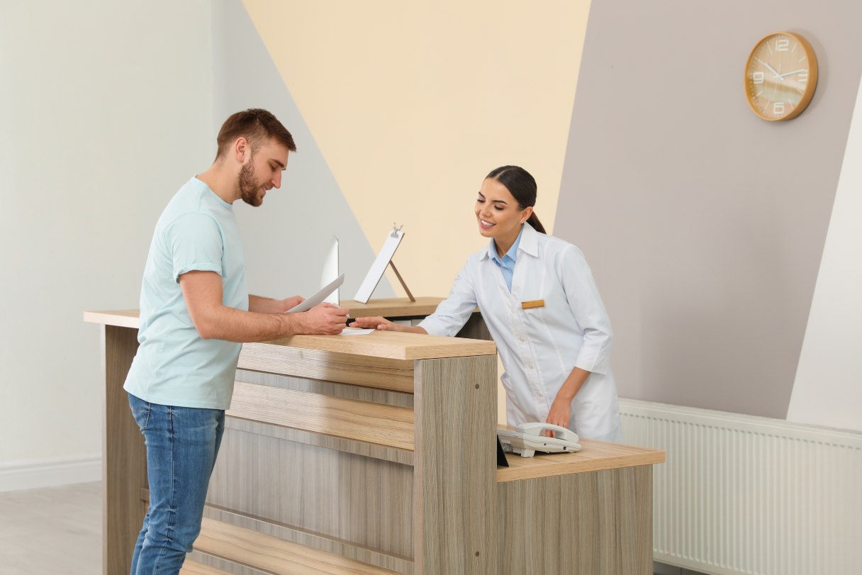 Man speaking with healthcare receptionist