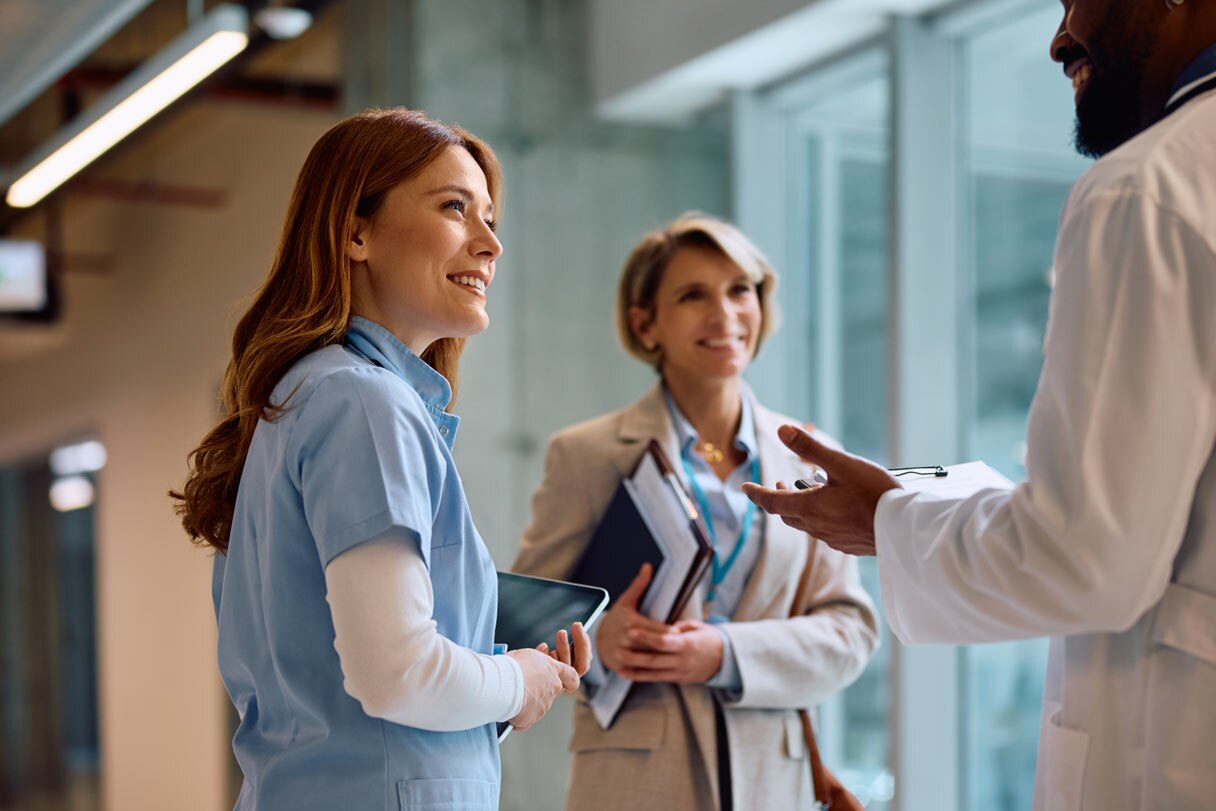Three healthcare professionals speaking to each other