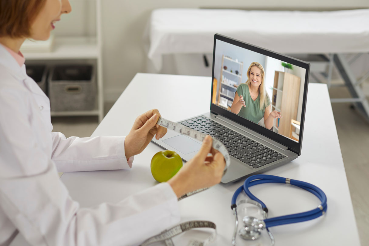 Provider on telehealth call with client, showing her tape measure