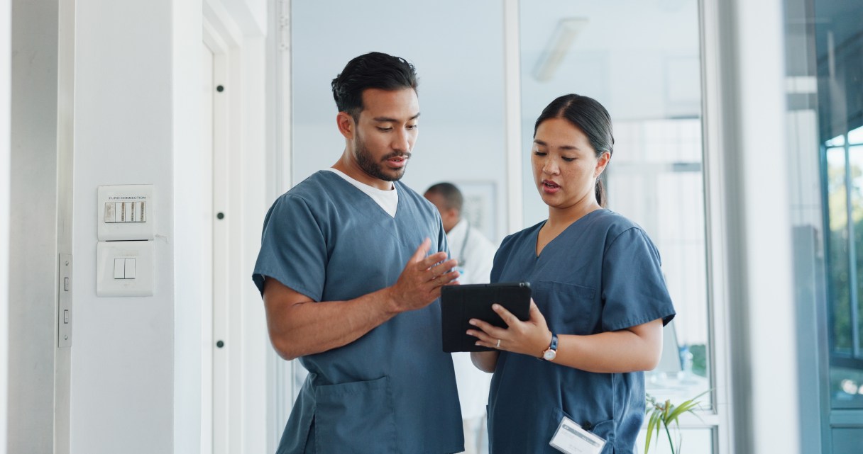 Two healthcare professionals looking at clipboard