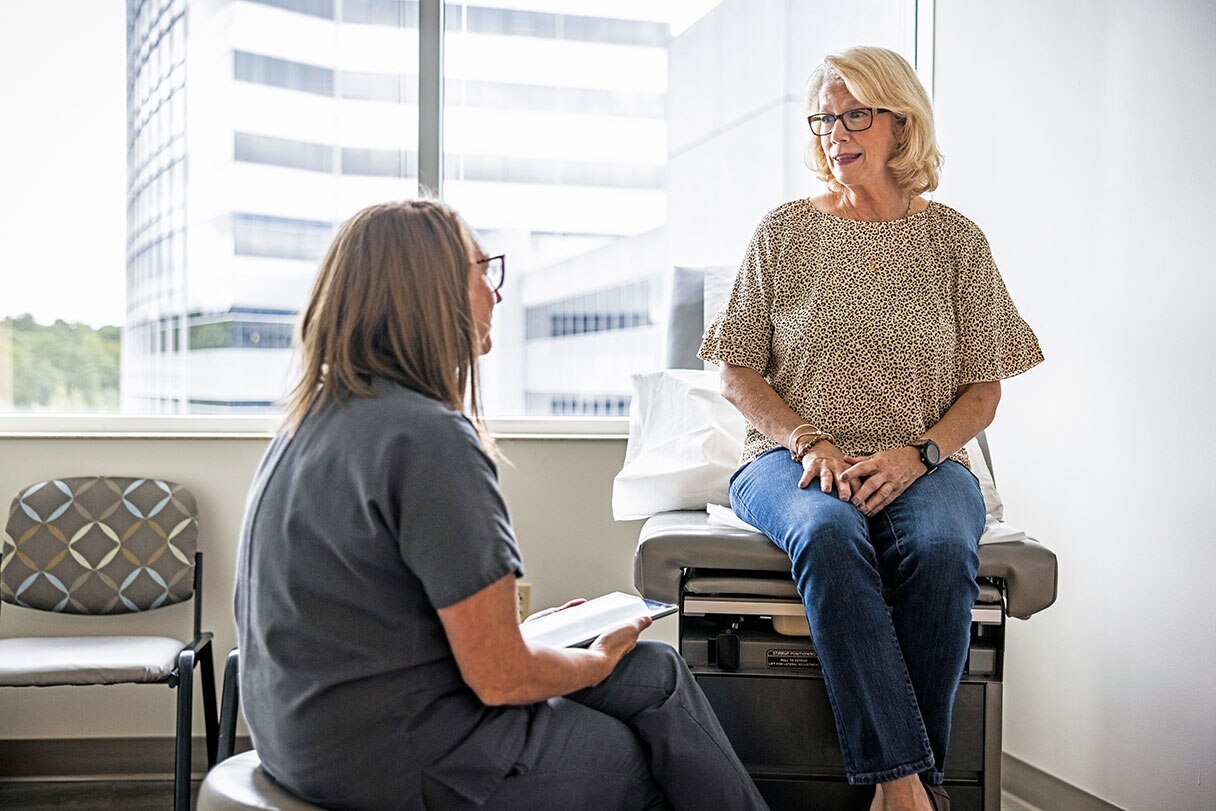 Provider speaking with patient sitting on exam table